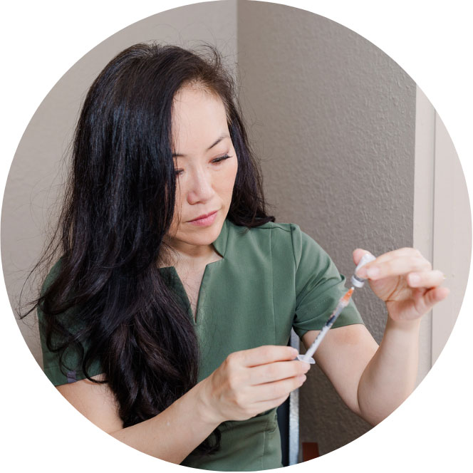 Dr. Christina H. Choe inserting the needle into the inverted vial